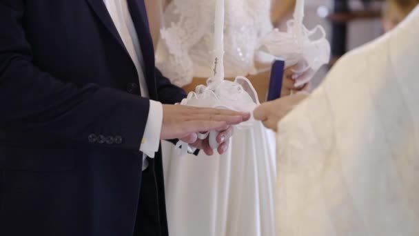 Священник молится в храме на свадебной церемонии и надевает кольца для молодоженов — стоковое видео