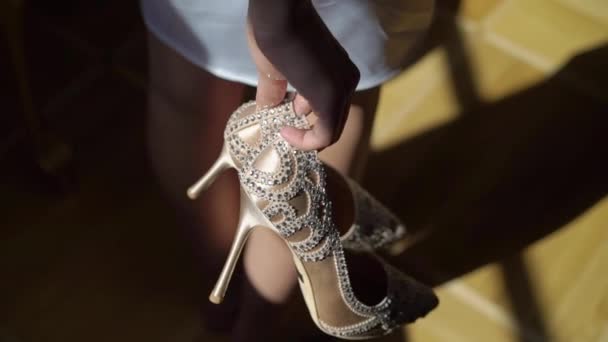 Young woman holding bridal wedding shoes — Stock Video