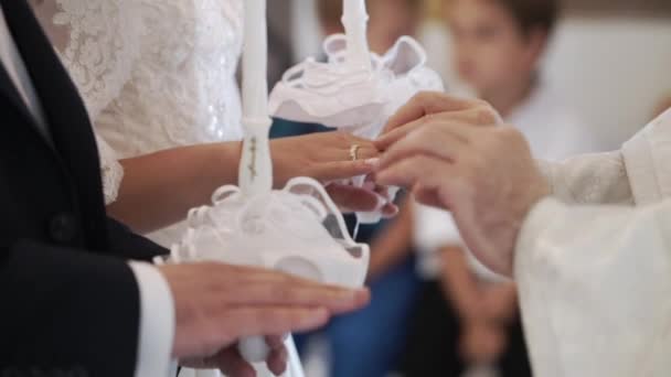 Priester bidden in kerk van huwelijksceremonie en ringen zetten voor pasgetrouwden — Stockvideo