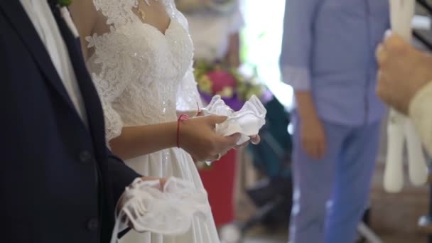 Bride and groom holding candles in church at ceremony — Stock Video