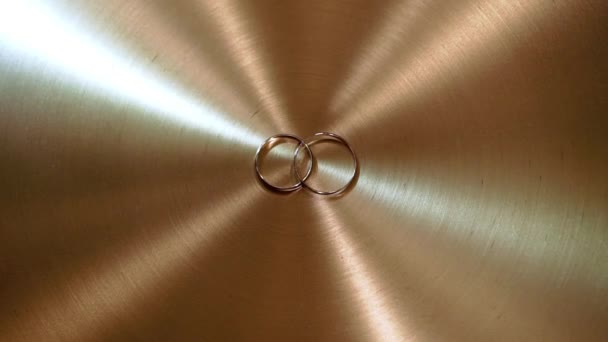 Wedding rings on golden background — Stock Video