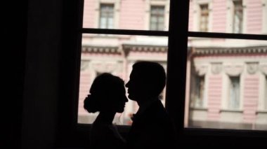 Öpüşme ve bir şehirde kucaklayan güzel çift silüeti