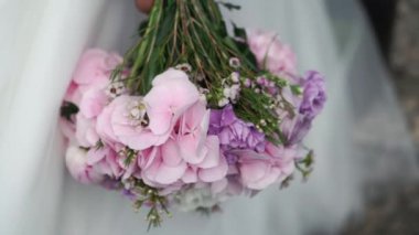 Mor çiçekli buket çiçek tutan gelin