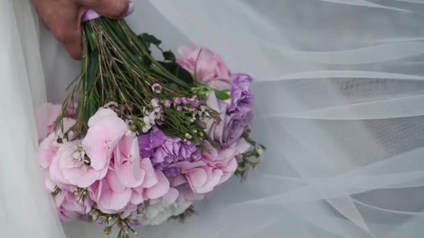 Bride holding flowers bouquet with violet flowers — Stock Video