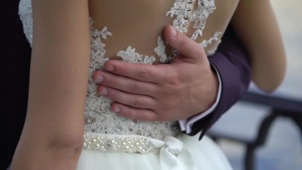 Bride and groom embracing in a city embankment — Stock Video