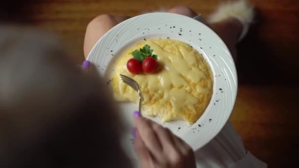 Widok z góry rąk kobiety cięcia kawałek jajko sadzone z noża i widelca. Zbliżenie jedzenie jajek sadzonych. Rano tradycyjne śniadanie jajka w biały talerz — Wideo stockowe