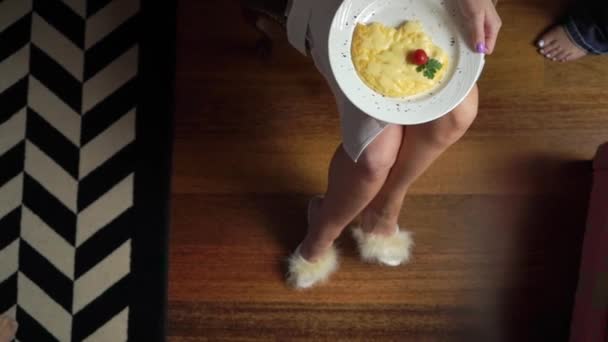 Vue du dessus des mains de la femme coupe morceau d'oeuf frit avec couteau et fourchette. Gros plan de manger des œufs frits. Petit déjeuner traditionnel œufs dans une assiette blanche — Video