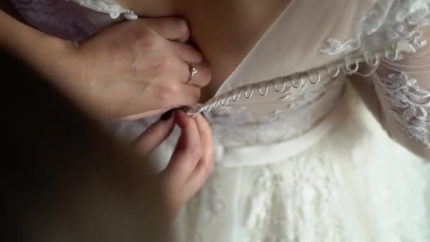 Gombolta menyasszony esküvői ruha Vértes. Rögzítés gomb, a menyasszonyi fehér ruha kezek — Stock videók