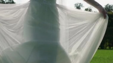 Uçan kumaş, sallayarak ile muhteşem gelinlik Genç gelin kadın moda kadın parkta poz