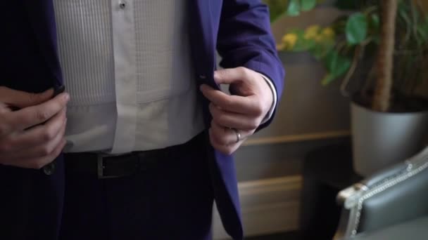 Крупный план рук жениха, застегивающих свадебную куртку . — стоковое видео