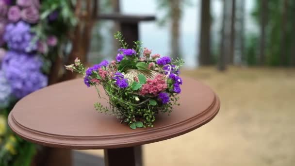 Boda. Ceremonia de boda. Arco, decorado con flores violetas y amarillas de pie en el bosque, en el área de la ceremonia de boda — Vídeos de Stock