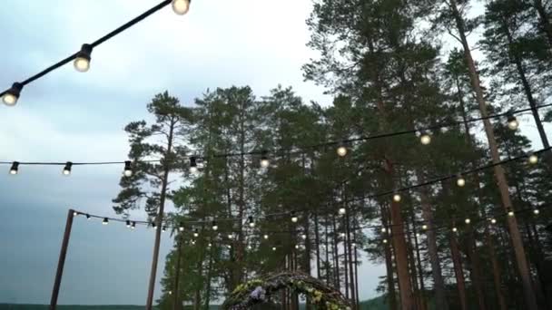 婚礼。婚礼。拱, 装饰着紫罗兰和黄色的花朵站在树林里, 在婚礼区 — 图库视频影像