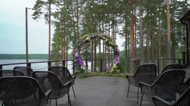 Casamento. Cerimônia de casamento. Arco, decorado com flores violetas e amarelas em pé na floresta, na área da cerimônia de casamento — Vídeo de Stock