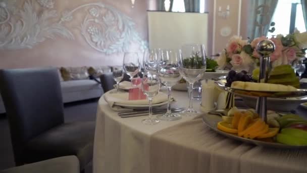 Святкова обстановка весільного столу з рожевими квітами, серветками, окулярами — стокове відео