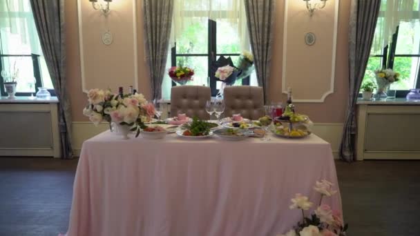 Fijación de mesa de boda festiva con flores rosadas, servilletas, vasos — Vídeo de stock