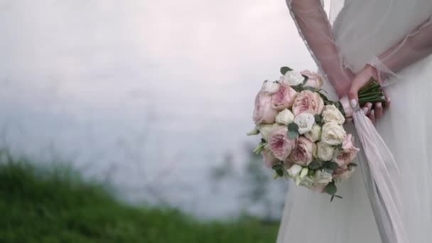 Braut hält ihren Strauß hinter ihrem Rücken — Stockvideo