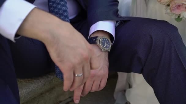 Lyckliga bröllopsparet sitter på trappan utomhus — Stockvideo