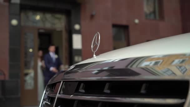 SAINT-PETERSBURG, RUSSIA - SEPTEMBER 9, 2018: White business class luxury Mercedes car, bride and groom on background unrecognizable — Stock Video