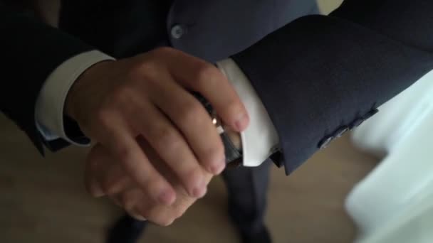 Businessman checking time on his wrist watch, man putting clock on hand, groom getting ready in the morning before wedding ceremony — Stock Video