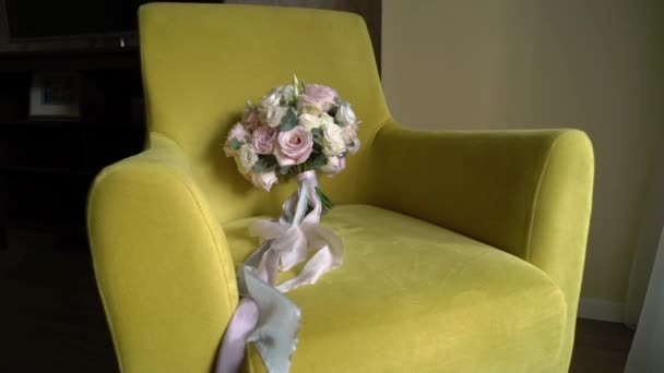Свадебный букет из розовых и белых роз, лежащих на стуле — стоковое видео