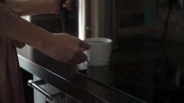 Mutfak, beyaz fincan çay dökme cam çaydanlık. Sabah kahvaltı zamanı. Neglegee çay bir fincan ile genç seksi kadın