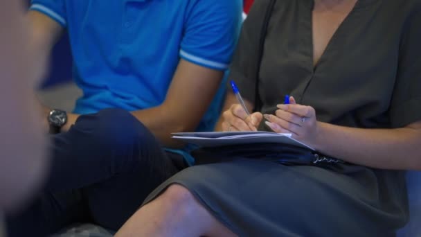 Primer plano de las manos sosteniendo bolígrafos y tomando notas en la conferencia — Vídeos de Stock