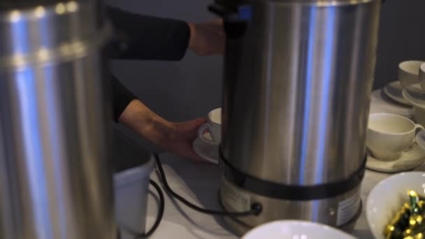 Omul toarnă apă caldă de la cazanul electric cu apă caldă pentru a face cafea sau ceai fierbinte — Videoclip de stoc