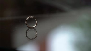 Altın yüzük elmas düğün cam masa üzerinde rulo
