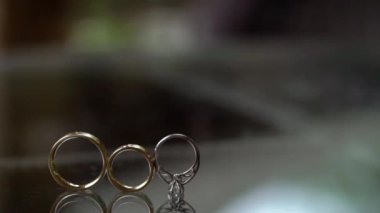 Altın yüzük elmas düğün cam masa üzerinde rulo