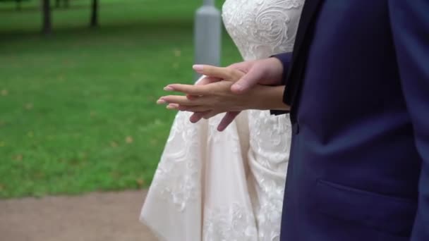 Mariée et marié en plein air se tenant la main et marchant dans un parc — Video