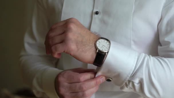 Geschäftsmann, der die Uhrzeit an seiner Armbanduhr überprüft, Mann, der die Uhr an der Hand hält, Bräutigam, der morgens vor der Trauung fertig wird — Stockvideo