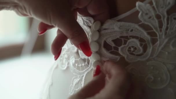 Closeup portret van een dienstbode of moeder helpen de bruid dragen haar jurk — Stockvideo