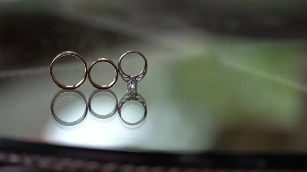 Inele de aur de nunta cu role de diamant pe masa de sticla — Videoclip de stoc