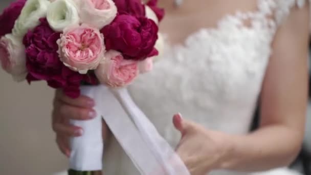 Menyasszony bouquet, fehér, rózsaszín és piros rózsa tartja. Hullámzó szalag. Szabadban slowmotion — Stock videók