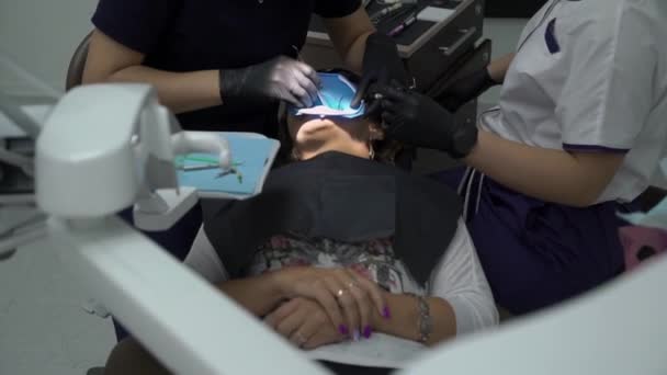 Tandarts behandeling tanden aan vrouw patiënt in kliniek. Vrouwelijke professionele arts stomatologist op het werk. Tandheelkundige check-up — Stockvideo