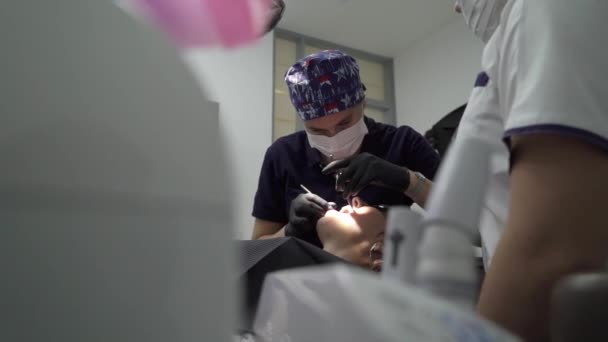 Tandarts behandeling tanden aan vrouw patiënt in kliniek. Vrouwelijke professionele arts stomatologist op het werk. Tandheelkundige check-up — Stockvideo