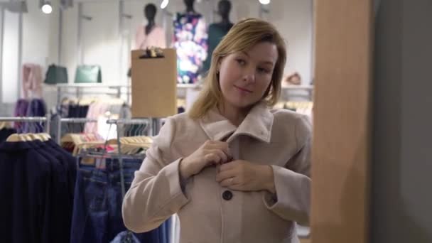 Hermosas mujeres jóvenes eligiendo ropa en la tienda — Vídeo de stock