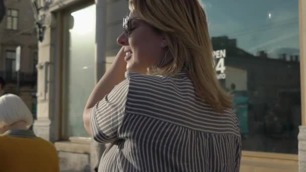 Ung blond kvinne smiler og poserer i en by – stockvideo