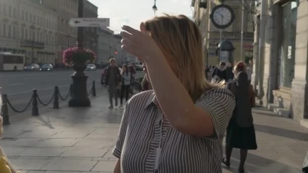 Mladá blond žena s úsměvem a pózuje ve městě — Stock video
