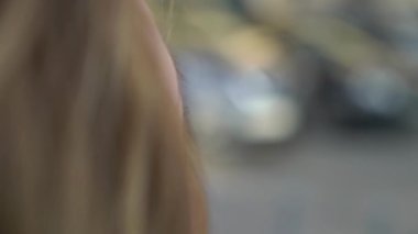 Gülümseyen ve bir şehirde poz sarışın genç kadın