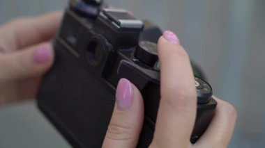 Gülümseyen ve yaz akşamları bir şehir slowmotion poz sarışın genç kadın. Elleri - fotoğrafçı ya da turist olarak eski retro film fotoğraf makinesi.