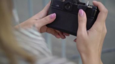 Gülümseyen ve bir şehirde poz sarışın genç kadın