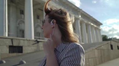 Gülümseyen ve bir şehirde poz sarışın genç kadın