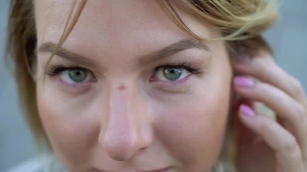 Young blonde woman smiling and posing in a city — Stock Video