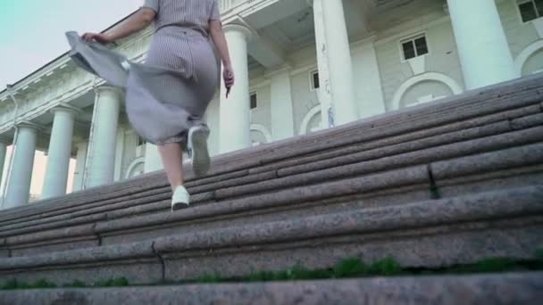 若いブロンドの女性の笑顔と夏夜市スローモーションでポーズします 階段宮殿の並木道付近 — ストック動画