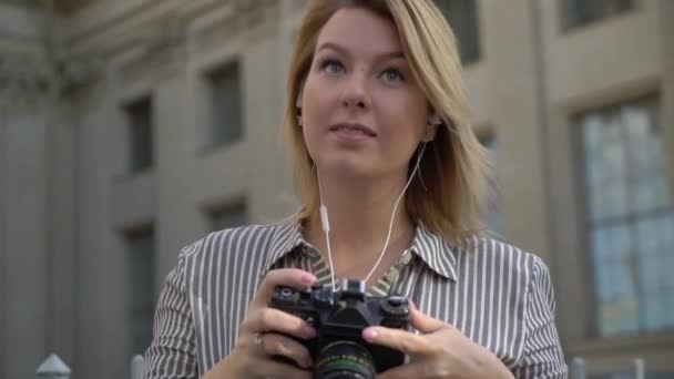 Gülümseyen ve bir şehirde poz sarışın genç kadın — Stok video