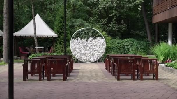 Hochzeit. Trauung. Bogen. Bogen, geschmückt mit weißen Blumen, die im Wald stehen, im Bereich der Hochzeitszeremonie — Stockvideo