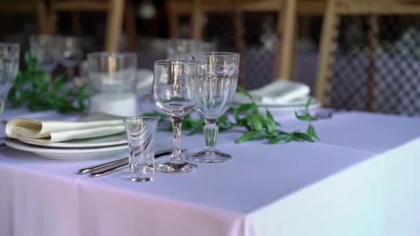 Table de banquet décorée, avec couverts. Décor de mariage dans la salle de banquet. Servir une table de fête, assiette, serviette, couteau, fourchette. Décoration de table. Dîner romantique ou autres événements . — Video