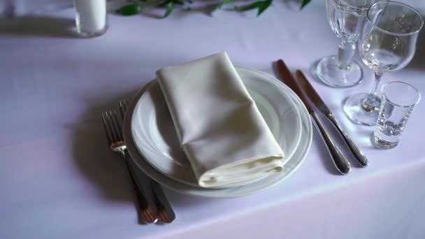 Table de banquet décorée, avec couverts. Décor de mariage dans la salle de banquet. Servir une table de fête, assiette, serviette, couteau, fourchette. Décoration de table. Dîner romantique ou autres événements .