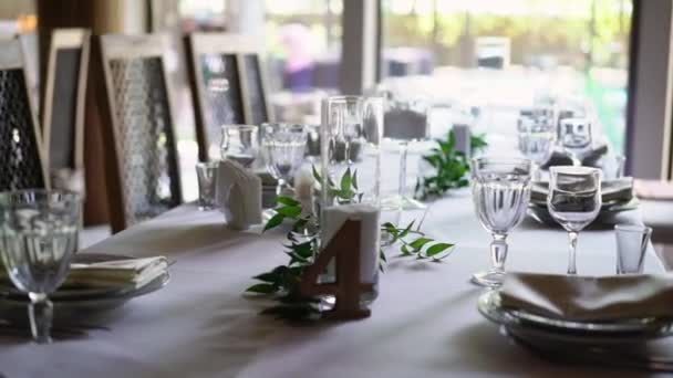 刃物で飾られたバンケット テーブル。宴会場での結婚式の装飾。お祝いテーブル、皿、ナプキン、ナイフ、フォークのサービング。テーブル設定の装飾。ロマンチックなディナーやその他のイベント. — ストック動画